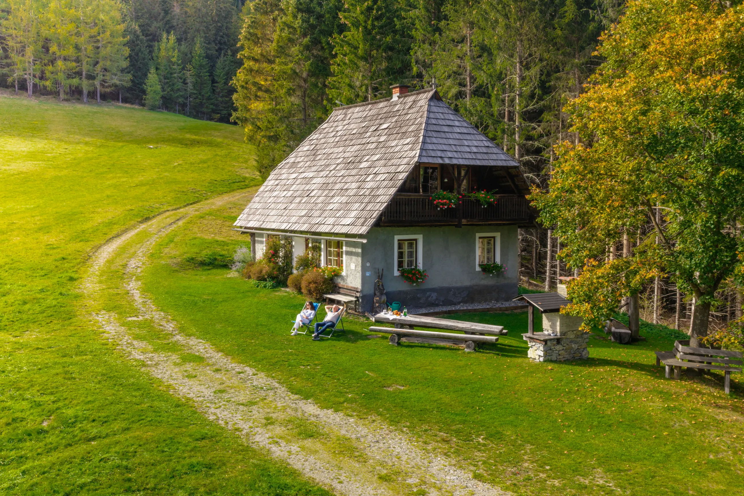 Luftbild: die Droneberger Hütte mit Liegestühlen, Holztisch und gemauertem Grill