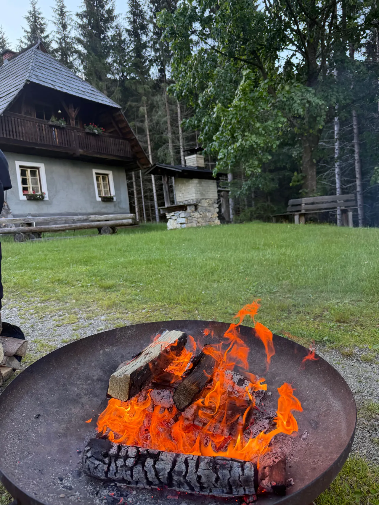 Feuerschale brennt abends vor der Hütte