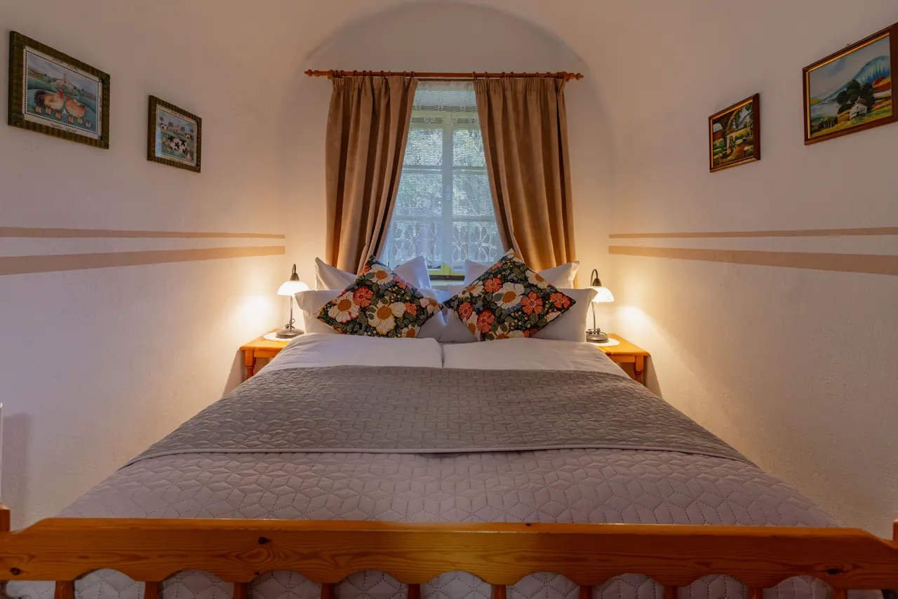 Zweites Schlafzimmer mit Doppelbett und geblümten Polstern