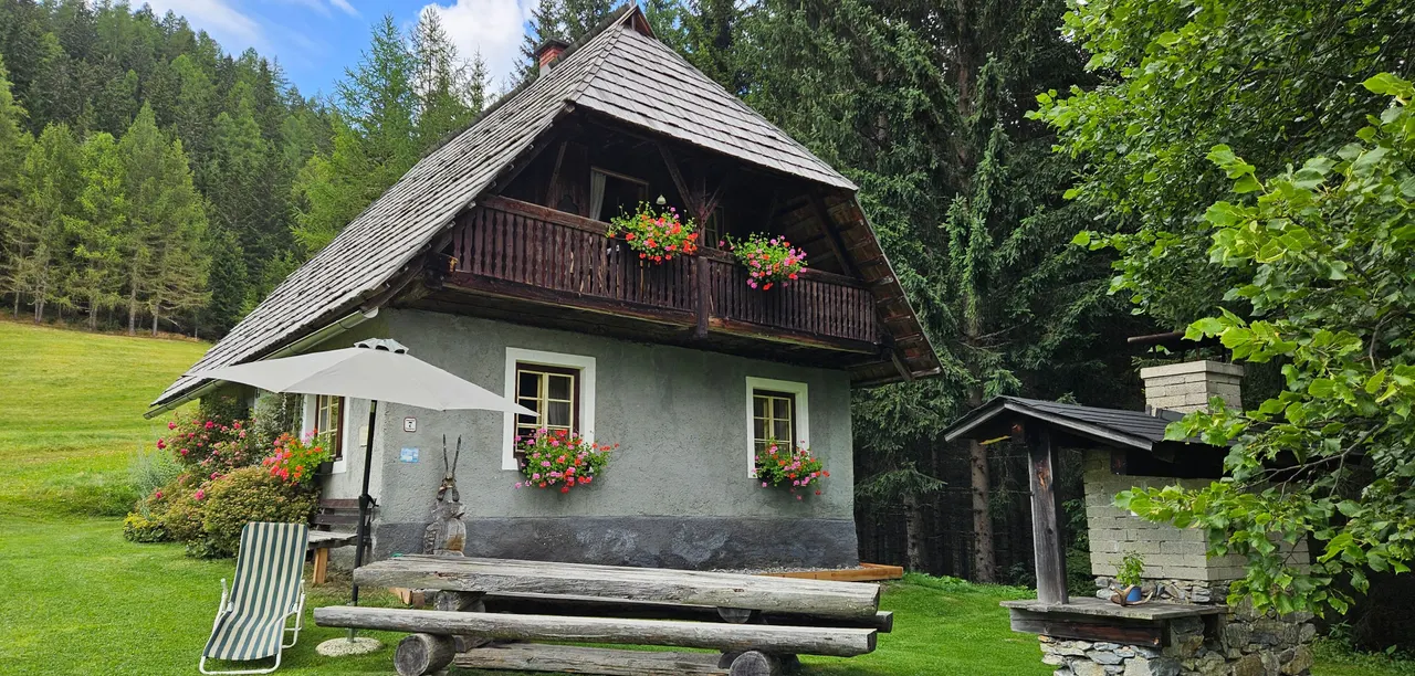 Die Hütte mit Sonnenschirm und Bank im Sommer